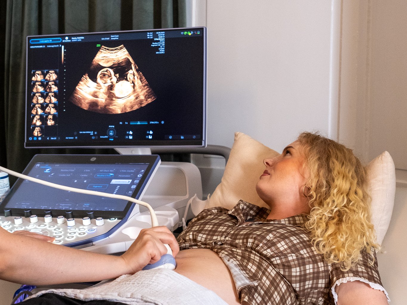 Expectant mother on the couch watching her baby on the screen