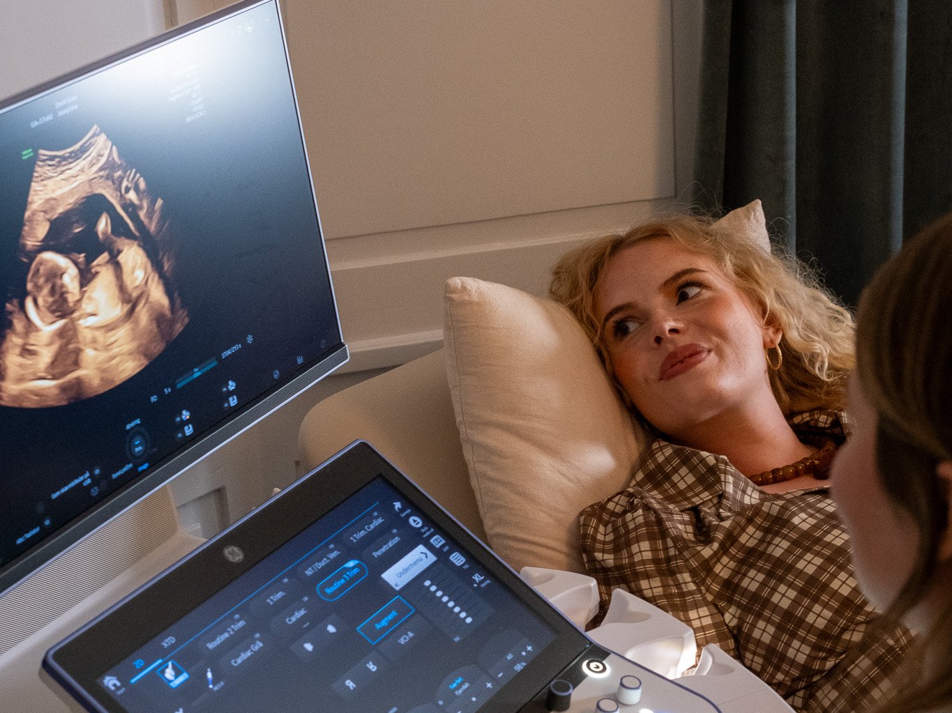 Pregnant woman talking with the sonographer during her scan at Stork Scan